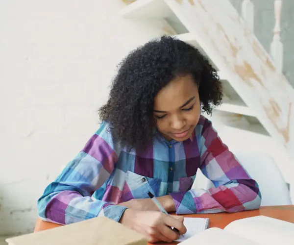 A student writing at her desk